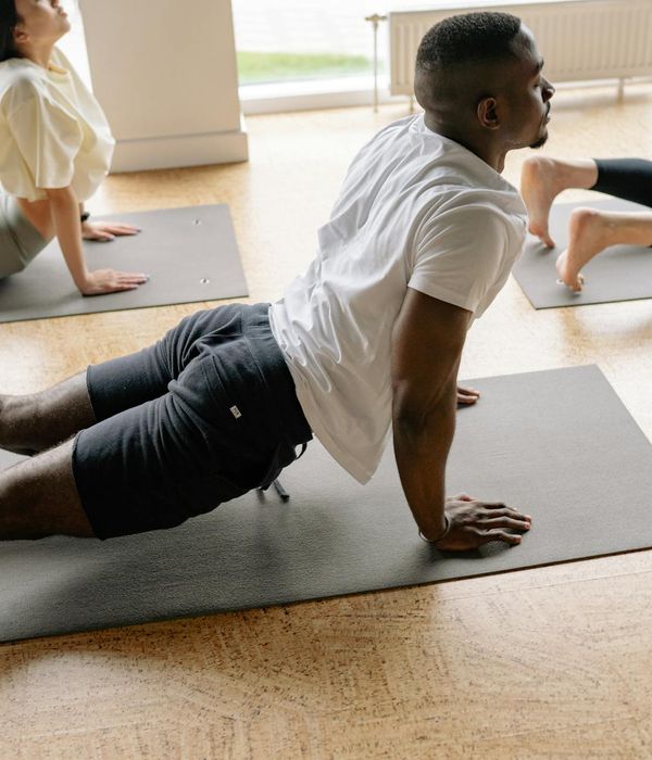 Woman practicing mindful yoga stretching in a warm amber lit studio.